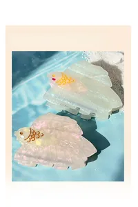 Detailansicht der fischförmigen Haarklammern aus Acetat in Rosa und Gelb auf Wasserhintergrund
