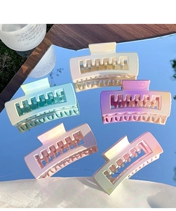 Lot de cinq pinces à cheveux rectangulaires dégradées macaron posées sur un miroir