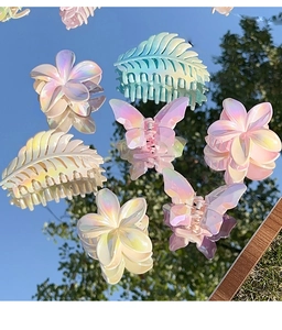 Close-up of iridescent butterfly and plumeria hair clips with a pearlescent finish