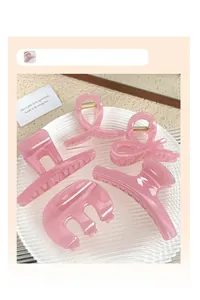 Detailed set of five pink resin hair claws in various shapes on a white tray