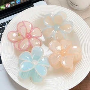 Pinze per capelli floreali in colori gelatina come rosa pastello e blu su piatto bianco