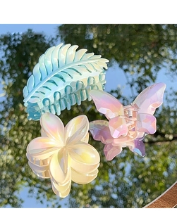Close-up of iridescent butterfly, leaf and flower hair claws with reflective mirror effect