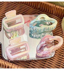 Detailed set of four iridescent hair claws showing pearlescent square and wavy designs