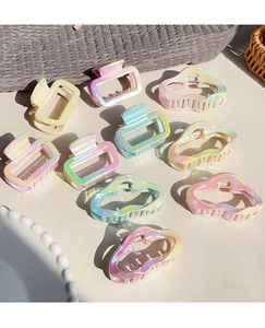 Close-up of matte gradient claw clips in rectangular and wave shapes with pearly finish