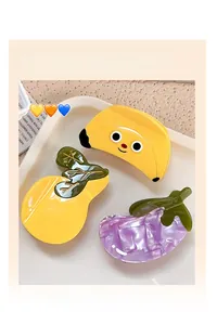 Close-up of cute fruit and vegetable hair claw clips including banana and eggplant shapes