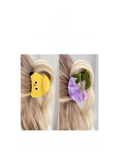 Detail showing cartoon banana and marble hair claw clips on long wavy hair