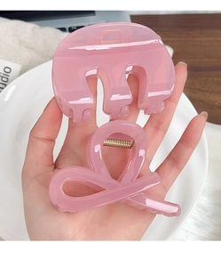 Close-up of pink jelly resin hair claw clips with strong gold metal springs for women