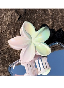 Macro view of pearlescent frangipani flower hair claw clip with gradient colors