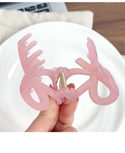 Close-up of a translucent jelly pink hair claw clip showing glossy finish and teeth