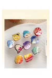 Colorful acetate shell hair claws with cute cartoon expressions in a white ceramic plate