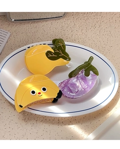 Detailed view of fruit hair claws like lemon and eggplant in a white ceramic dish