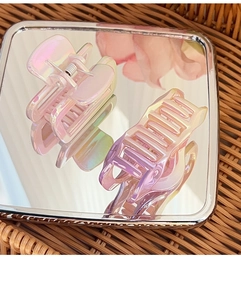 Macro shot of laser gradient hair claw clip showing mirror reflection and gear details