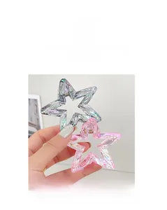 Close-up of laser iridescent star-shaped hair claws in pink and silver finish