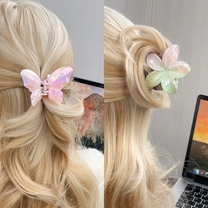 Iridescent butterfly and flower hair claws with gradient pearl finish on long blonde hair