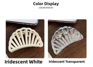 Detail view of shell-shaped hair claw clips in iridescent white and transparent holographic finish