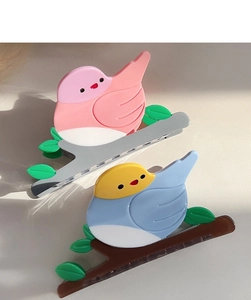 Detalle de dos pinzas para el cabello con forma de pájaro en acetato rosa y azul claro