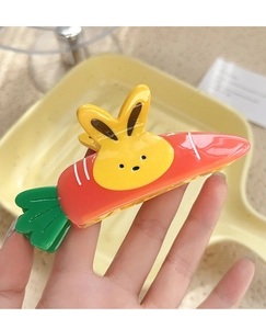 Detail of the cute carrot and bunny claw clip with a glossy finish and strong grip teeth