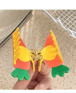 Detailed view of handmade carrot claw clip showing vibrant orange acetate and gold metal spring