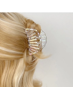 Detailed view of iridescent semi-circle shark clip on blonde hair for half-up hairstyles