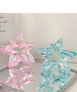 Detail of star hair clips in candy colors with iridescent laser effect on mirror