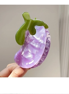Macro detail of eggplant shaped hair claw made from purple marbled acetate material