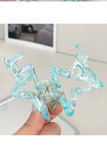 Detail of blue iridescent star hair claw showing translucent resin and metal spring
