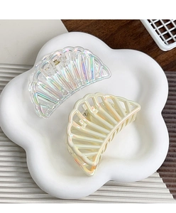 Detail of iridescent and pearl white semicircular hair claws on a floral tray