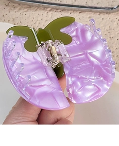 Detailed close-up of large marbled purple and olive green acetate vegetable hair claw clip