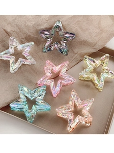 Macro shot of colorful star-shaped claw clips with holographic gem textures on a tray