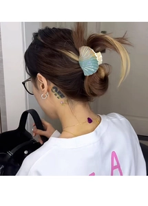 Detail of a large holographic shell hair claw clip styled on a model's hair