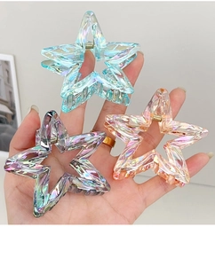 Close-up of star-shaped hair claws in translucent laser resin with gold metal spring