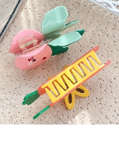 Close-up of pink peach and orange carrot vegetable shaped hair claws in acetate