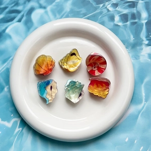 Cute Q-version animal acrylic hair claw clips in various colors on a ceramic plate