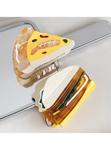 Macro detail of pizza and sandwich shaped acetate hair claws on a reflective mirror