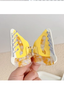 Close-up of butterfly hair claw clip made of yellow and marble acetate with metal spring