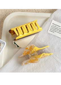 Close-up of yellow matte and marble texture acetate hair claws for ponytail styling