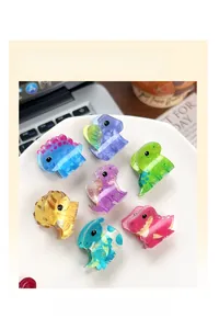 Detailed close-up of colorful acrylic dinosaur hair clips in vibrant marble finishes