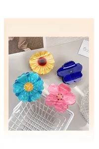 Detailed macro view of four acrylic flower hair claw clips with pearlescent marble texture