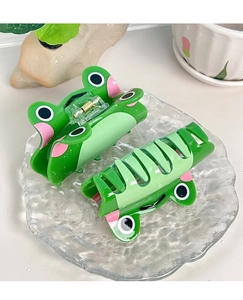 Détail de deux pinces à cheveux grenouille verte avec décorations de gouttes d'eau en relief