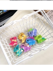 Mini acrylic dinosaur hair clips set in a small basket with colorful cartoon patterns
