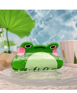 Gros plan d'une pince à cheveux grenouille verte avec gouttelettes d'eau sur fond bleu