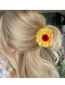 Detail of sunflower hair claw clip made of acrylic worn by a model for a half-up hairstyle