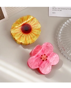 Close-up of sunflower and pink flower hair claws in acrylic marble texture finish