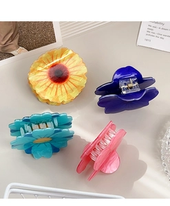Detail of four colorful acetate flower hair claws with marble texture and metal spring