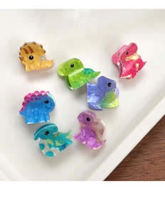 Detail of colorful mini acrylic dinosaur hair clips with marble texture on white tray