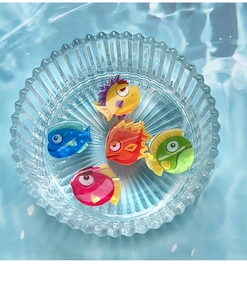 Détail de cinq pinces à cheveux requin en acrylique coloré dans un plat en verre strié