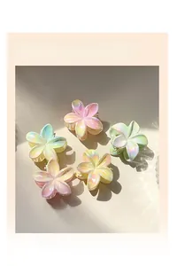 Macro view of five colorful pearlescent frangipani hair claw clips with gradient finish
