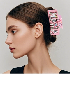 Detail of pink MAMA square hair claw clip with colorful floral pattern worn by a model