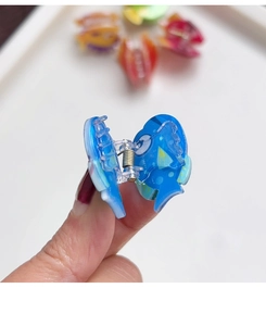 Gros plan sur la pince à cheveux en acrylique bleu en forme de poisson transparent