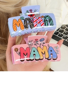 Detailed macro view of large acrylic MAMA hair claw clips with floral and rainbow patterns